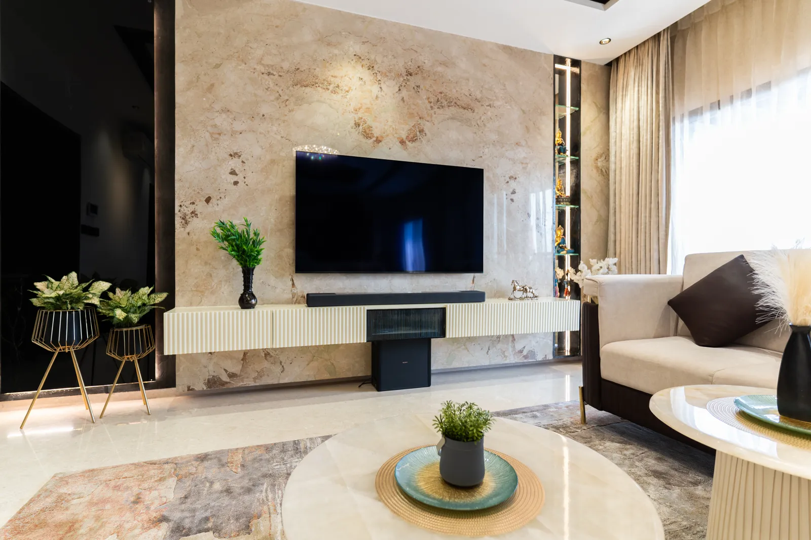 Living room with onyx TV wall, floating console and round coffee table — Abhishek's Residence